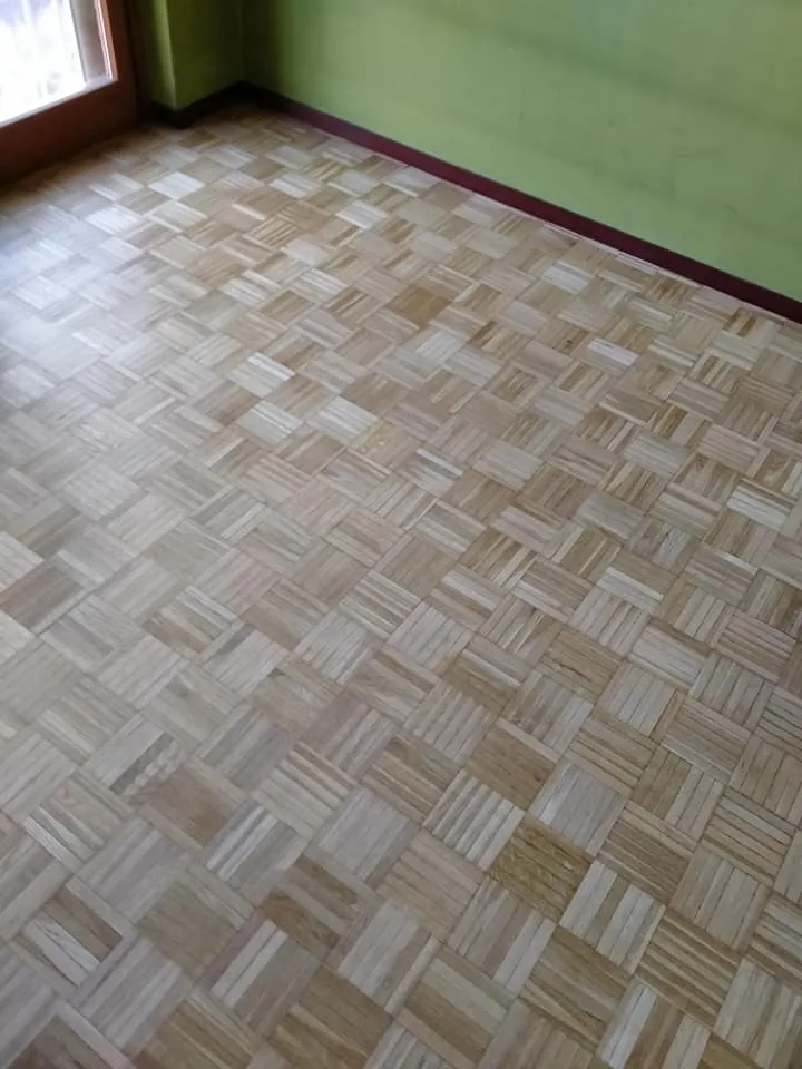 Pavimento a intreccio con posa a cesto davanti a una parete verde